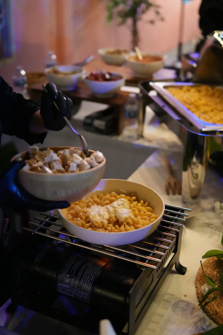 Préparation d’une portion de pâtes avec poulet lors d’une animation culinaire en entreprise.