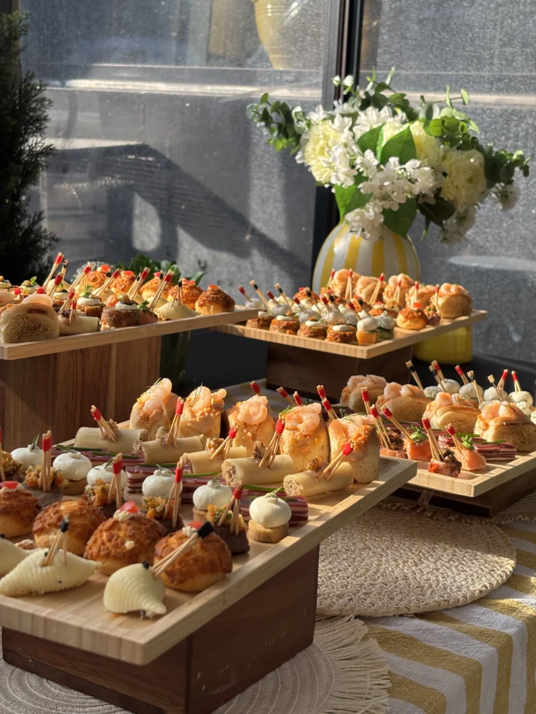 Buffet de pièces cocktail salées présenté sur des plateaux en bois pour un séminaire d’entreprise